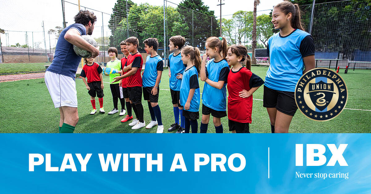 A soccer player high-fives a youth soccer team on the field. Text - "PLAY WITH A PRO' with the IBX and Philadelphia Union logos